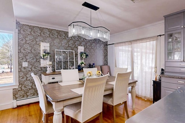 dining room with plenty of natural light, baseboard heating, crown molding, and wallpapered walls