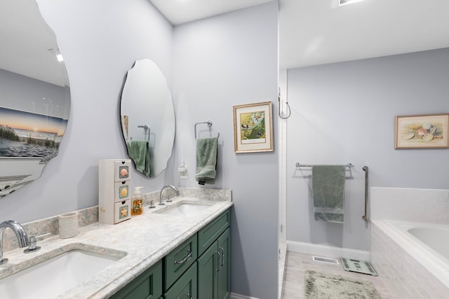 bathroom with vanity and tiled tub