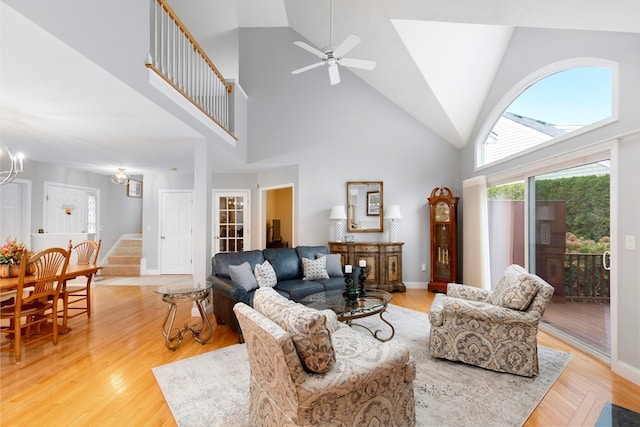 living room with high vaulted ceiling and light wood-type flooring