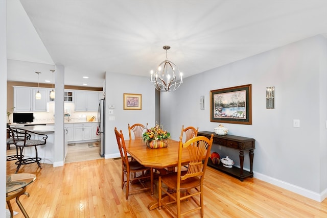 dining area featuring light hardwood / wood-style floors and an inviting chandelier