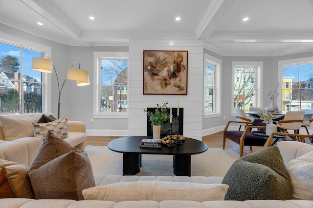 living room featuring a fireplace, ornamental molding, light hardwood / wood-style floors, and beamed ceiling