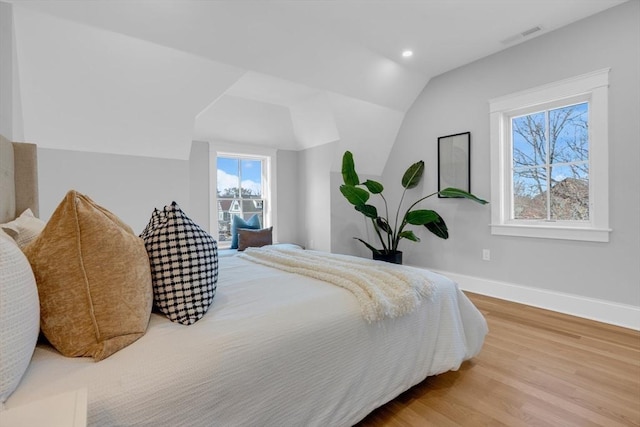 bedroom with wood-type flooring and lofted ceiling