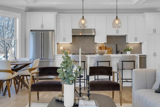 kitchen with white cabinetry, extractor fan, high end refrigerator, and pendant lighting