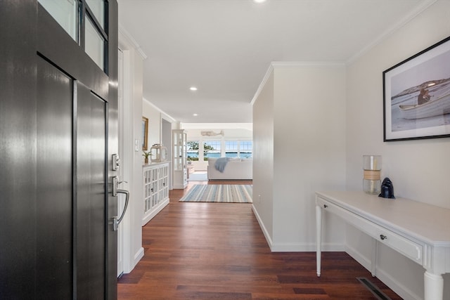 hall featuring ornamental molding and dark hardwood / wood-style flooring