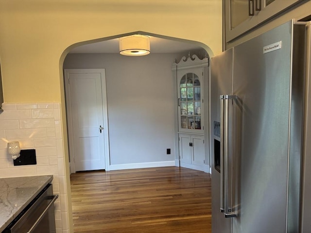 167 Pleasant St, East Longmeadow, MA 01028 - kitchen featuring high end refrigerator, arched walkways, dark wood finished floors, stone counters, and baseboards