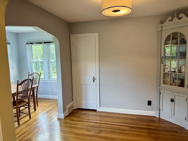 167 Pleasant St, East Longmeadow, MA 01028 - dining space with arched walkways, baseboards, and light wood-style flooring