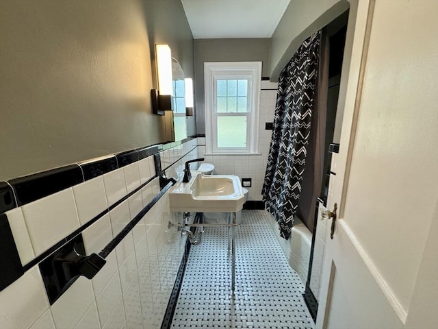 167 Pleasant St, East Longmeadow, MA 01028 - bathroom featuring tile walls, a wainscoted wall, shower / bath combo with shower curtain, and a sink