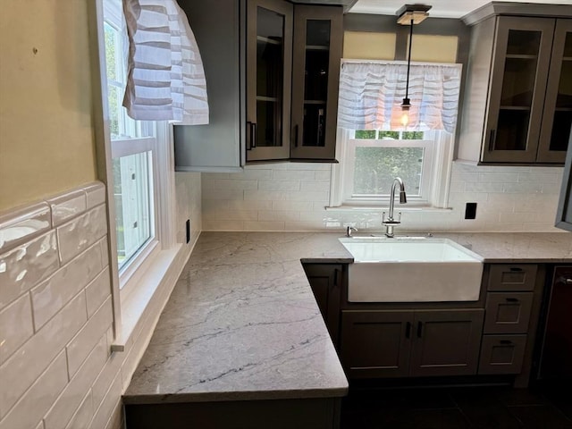 167 Pleasant St, East Longmeadow, MA 01028 - kitchen with a sink, light stone counters, backsplash, decorative light fixtures, and glass insert cabinets
