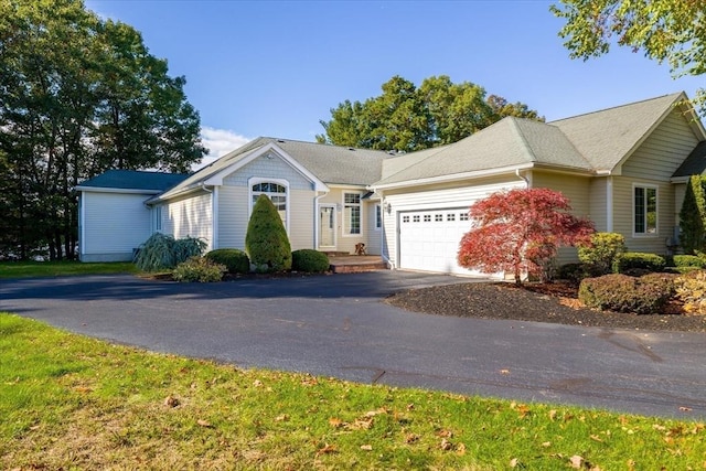 ranch-style house with a garage and aphalt driveway