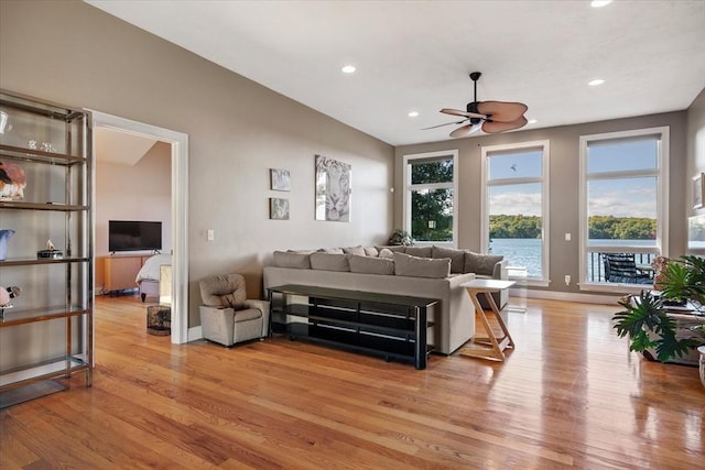 living area with a healthy amount of sunlight, a ceiling fan, and light wood-style flooring