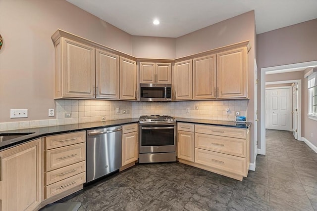 kitchen featuring light brown cabinetry, tasteful backsplash, dark countertops, and stainless steel appliances