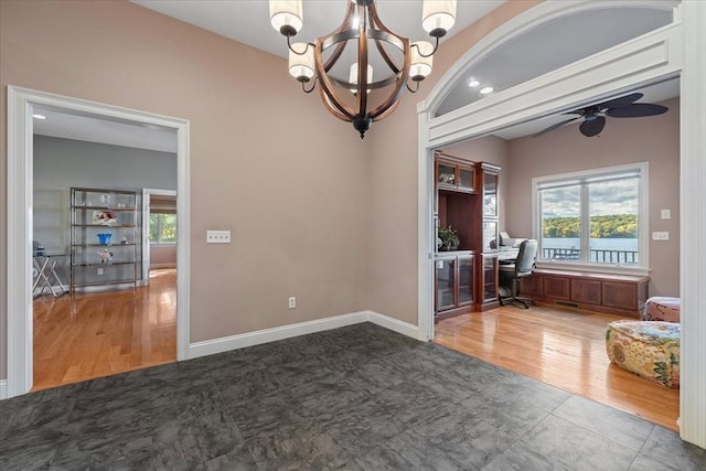 interior space featuring ceiling fan with notable chandelier and wood finished floors