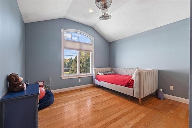 bedroom featuring visible vents, baseboards, light wood finished floors, and lofted ceiling