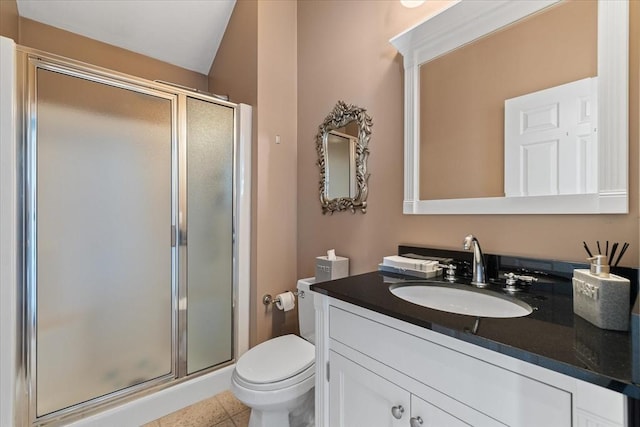 bathroom featuring vanity, toilet, tile patterned flooring, and a stall shower