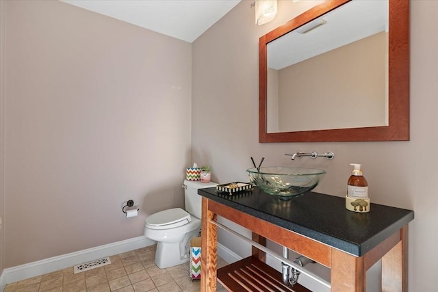bathroom featuring visible vents, baseboards, tile patterned floors, vanity, and toilet