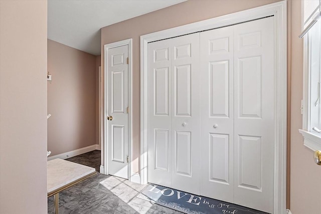 interior space featuring baseboards, a closet, and marble finish floor