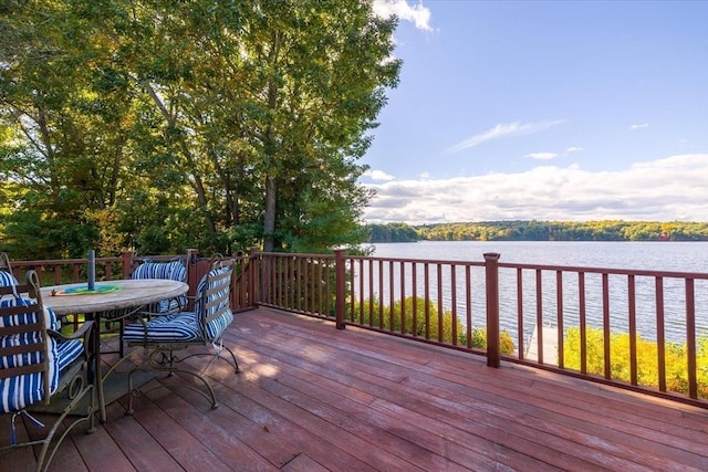 wooden terrace with outdoor dining area and a water view