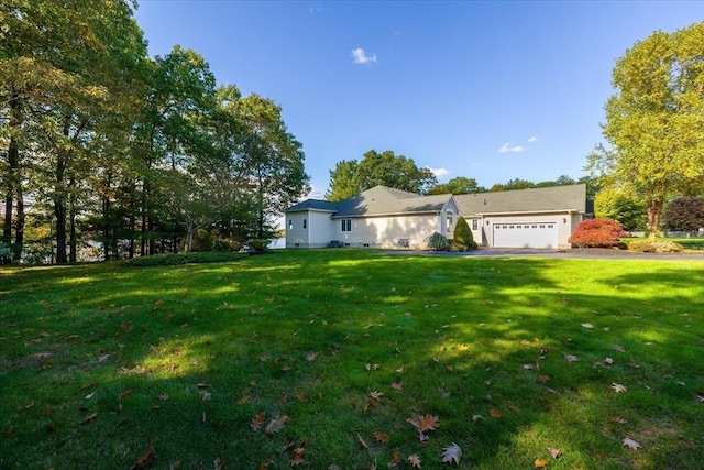 view of yard featuring driveway and a garage