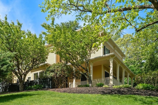 view of home's exterior with a yard and covered porch