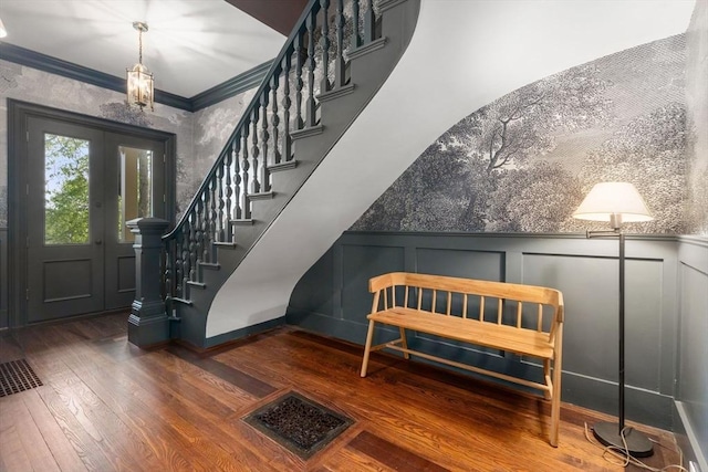 foyer featuring a decorative wall, hardwood / wood-style floors, stairway, a wainscoted wall, and ornamental molding