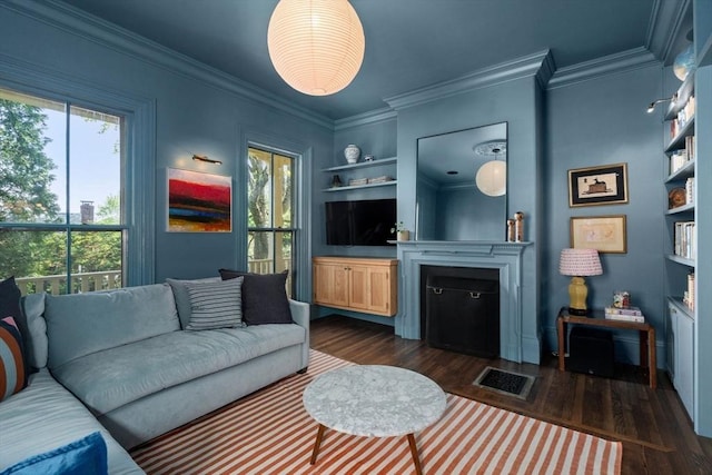 living area featuring dark wood-style floors, a fireplace, built in features, and ornamental molding