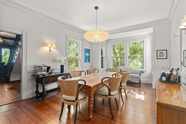 dining area with dark wood-style floors, ornamental molding, and baseboards