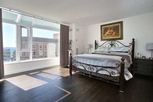 bedroom featuring wood finished floors, ornamental molding, and baseboards