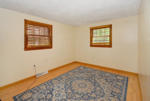 unfurnished room with hardwood / wood-style flooring