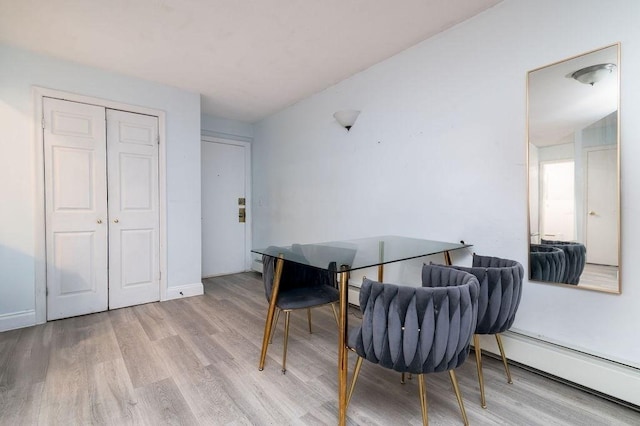 home office with a baseboard heating unit and light wood-type flooring