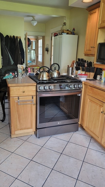 kitchen with black range with gas stovetop and light tile patterned floors