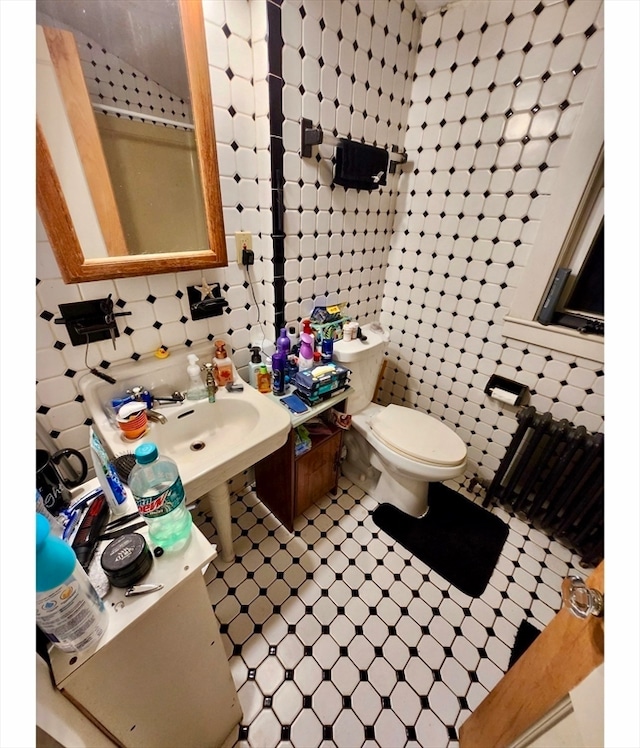 bathroom with tile walls, radiator heating unit, tasteful backsplash, and toilet