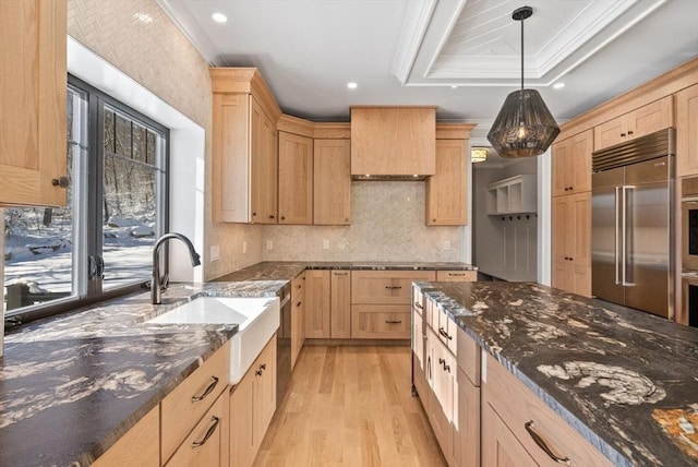 kitchen with crown molding, light brown cabinetry, decorative light fixtures, a raised ceiling, and stainless steel appliances