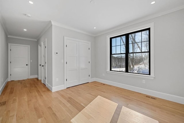 unfurnished bedroom featuring light hardwood / wood-style floors, a closet, and ornamental molding