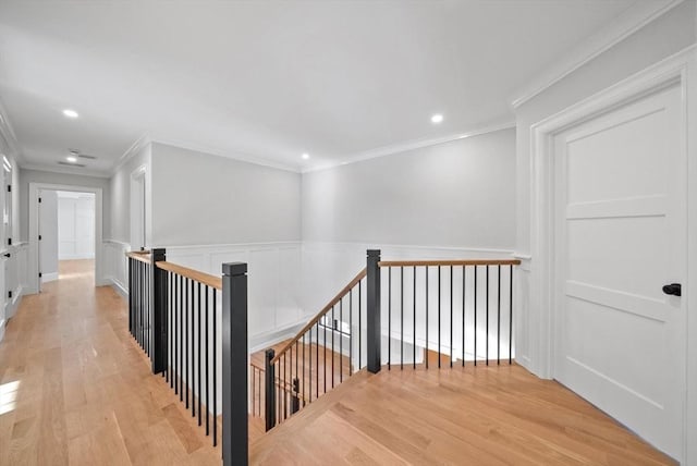 hallway with ornamental molding and light hardwood / wood-style floors