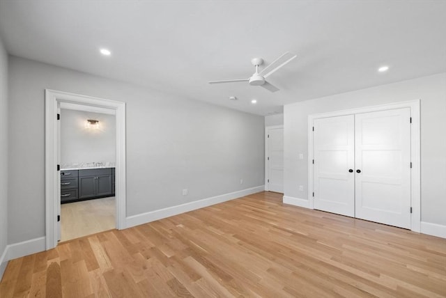 unfurnished bedroom with light hardwood / wood-style floors, a closet, ensuite bath, and ceiling fan