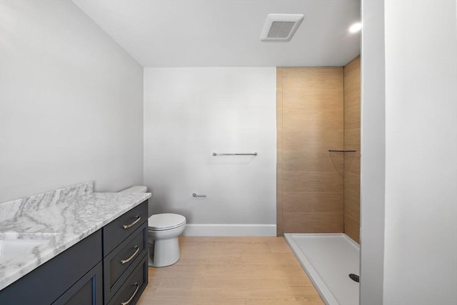 bathroom featuring a shower, toilet, and vanity