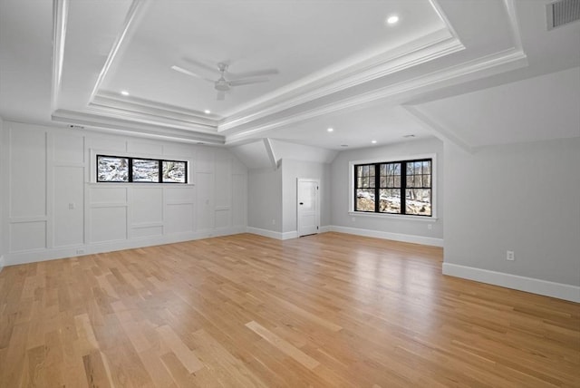 unfurnished living room featuring light hardwood / wood-style flooring, a tray ceiling, and ceiling fan