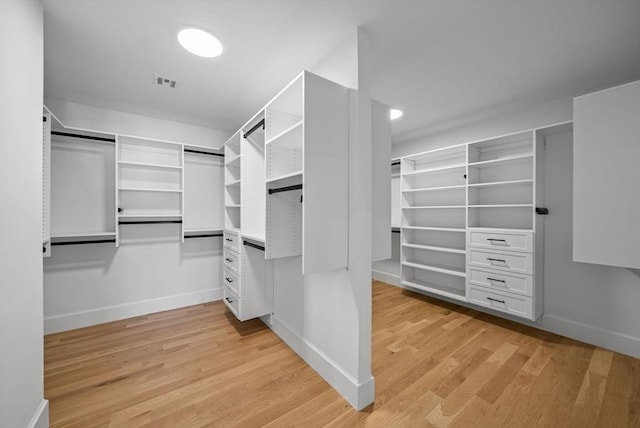 walk in closet with light hardwood / wood-style flooring