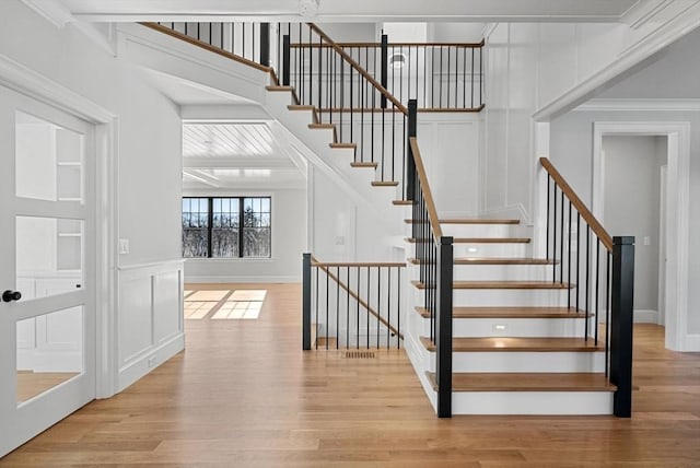 staircase featuring crown molding and wood-type flooring