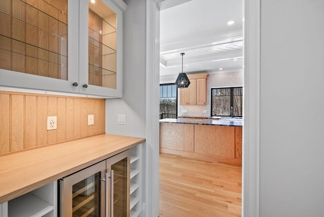 bar with backsplash, pendant lighting, light wood-type flooring, and wine cooler