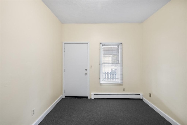 unfurnished room featuring a baseboard radiator and dark carpet