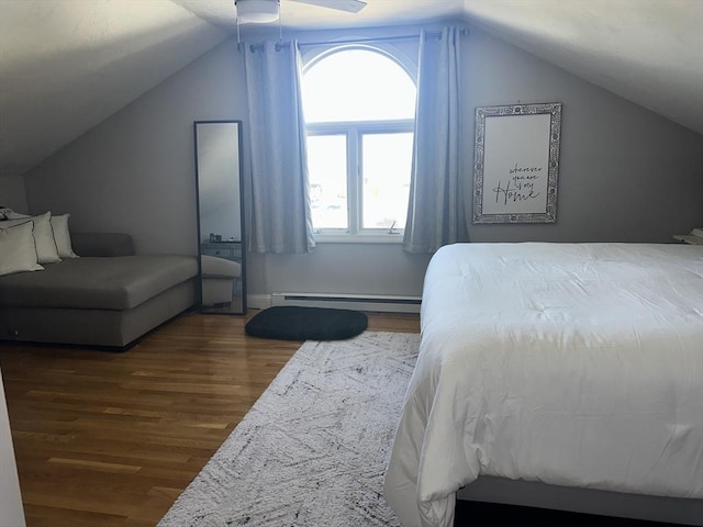 bedroom featuring a baseboard heating unit, vaulted ceiling, dark wood finished floors, and a ceiling fan