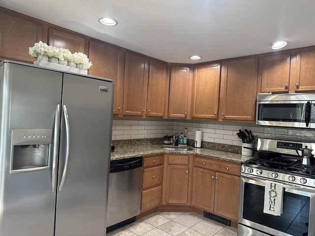 kitchen with light tile patterned flooring, recessed lighting, stainless steel appliances, a sink, and tasteful backsplash