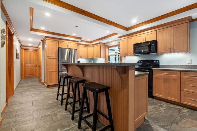 kitchen with dark countertops, a breakfast bar, a center island, ornamental molding, and black appliances