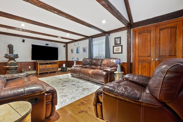 living room with beamed ceiling, a wainscoted wall, wood-type flooring, and wood walls