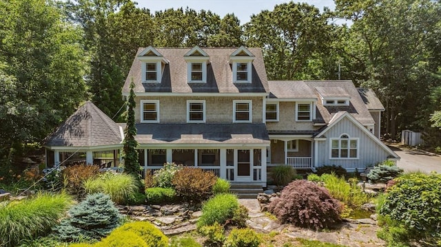 view of front facade with board and batten siding and roof with shingles