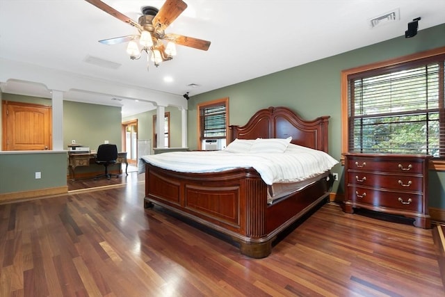 bedroom with decorative columns, ceiling fan, visible vents, and dark wood finished floors