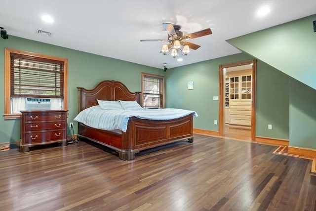 bedroom with baseboards, multiple windows, wood finished floors, and visible vents