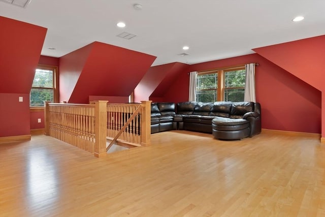additional living space featuring baseboards, wood finished floors, and a healthy amount of sunlight