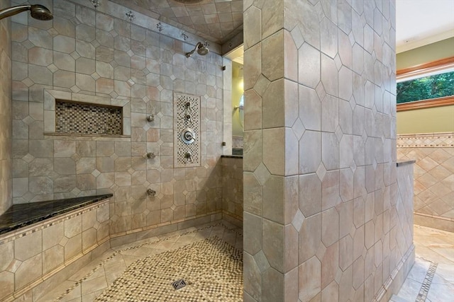 full bathroom with tile walls, tiled shower, and tile patterned flooring